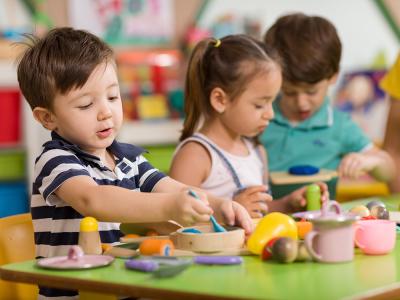 Kinder basteln am Tisch in einer Kindertagesstätte