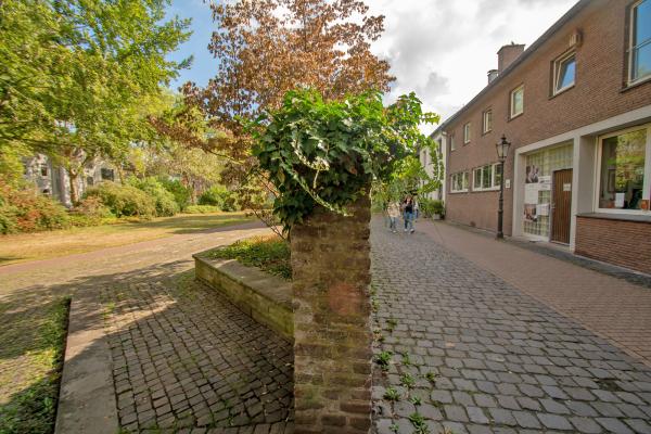 Gasse entlang der Stadtmauer mit Wohnhäusern und kleinem Park