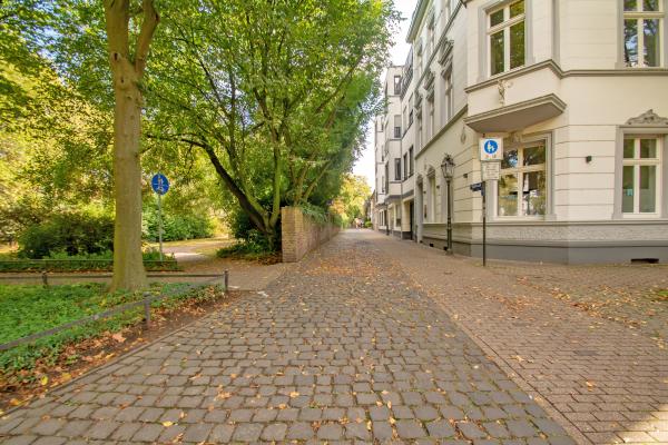 Gasse mit Wohnhäusern und Zugang zu einem kleinen Park