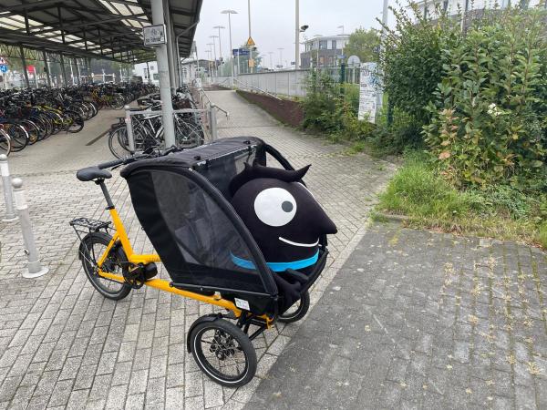 Lastenrad Chike Lastenrad Chike mit Stofftier "Edgar" vor der Fahrradabstellanlage am Bahnhof