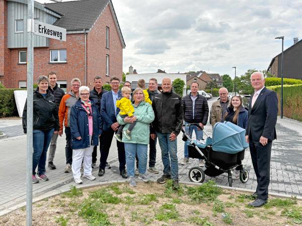 Fertigstellung Kanalbaumaßnahme Erkesweg Anwohner*innen mit Vertreter*innen der Stadtverwaltung stehen auf neuer Straße im Wohngebiet