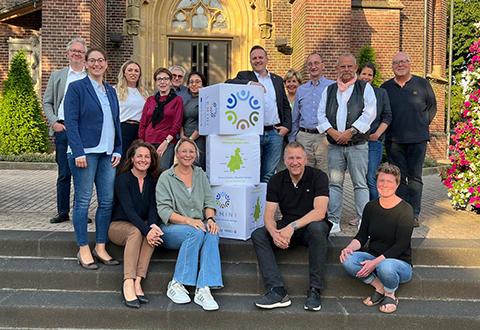 Beteiligte Menschen stehen auf einer Treppe vor einer Kirche